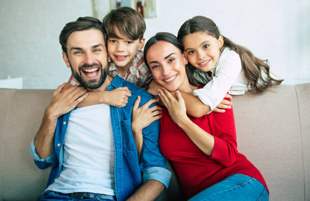 Young happy family relax together at home smiling and hugging